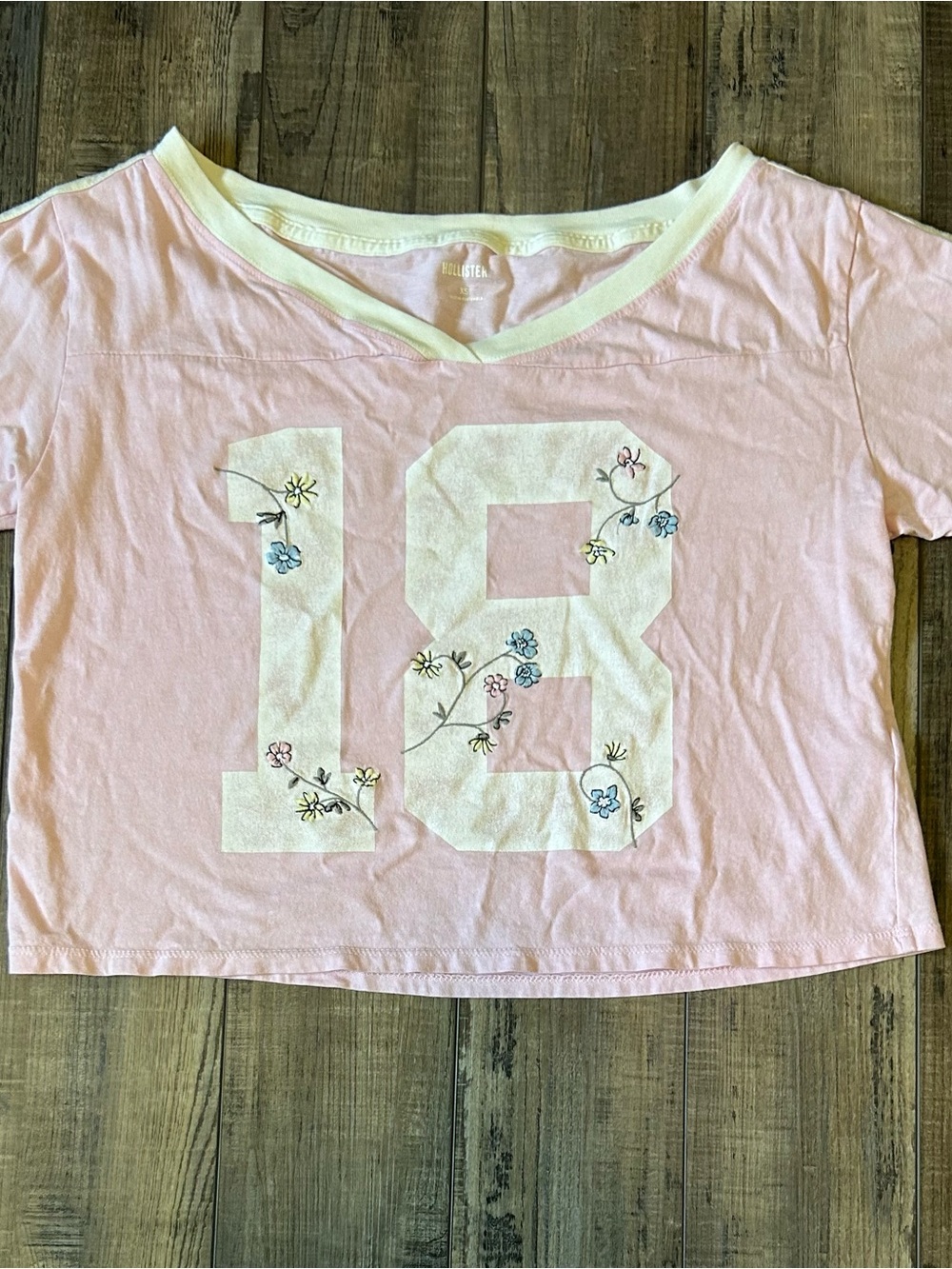 Hollister Light Pink V‑Neck Tee with White '18' and Floral Accents